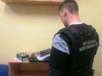 policjant zabezpiecza odzyskane przedmioty