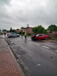 policjanci na miejscu wypadku, widac rozbity pojazd i radiowóz