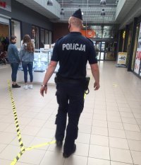 umundurowany policjant patroluje galerię handlową