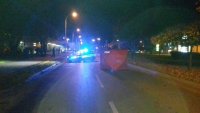 Sieradz ul. Aleja Grunwaldzka, miejsce wypadku drogowego, widać stojący na ulicy oznakowany policyjny radiowóz, czerwony namiot , po obu stronach drogi zabudowania,  bloki mieszkalne