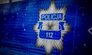 na niebieskim tle odznaka policyjna, gdzie pod napisem POLICJA umieszczony jest numer 112