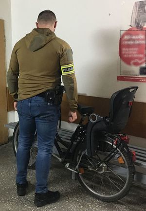 na korytarzu w budynku komendy obok odzyskanego  z kradzieży roweru stoi policjant