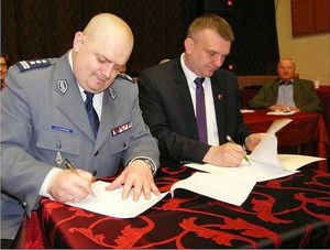 Przy stole siedzi Starosta Sieradzki oraz Komendant Wojewódzki Policji w Łodzi i podpisują dokument