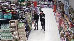 Dwaj mężczyźni chodzą po terenie sklepu między regałami.