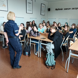 W sali lekcyjnej w szkole policjantki prowadzą pogadankę z uczniami.