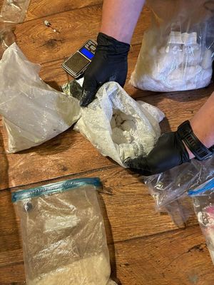 Czynności policjantów na miejscu ujawnienia narkotyków przechowywanych w torbach foliowych w pomieszczeniach mieszkalnych sprawcy.