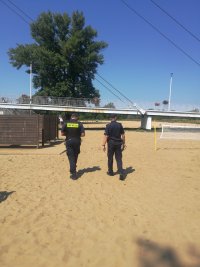 policjant i strażnik miejski patrolują plażę