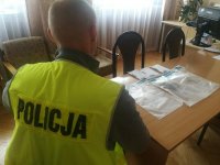 policjant wykonuje oględziny zabezpieczonych środków odurzających