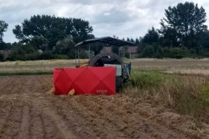 miejsce wypadku, na polu stoi kombajn ziemniaczany, z przodu czerwony parawan