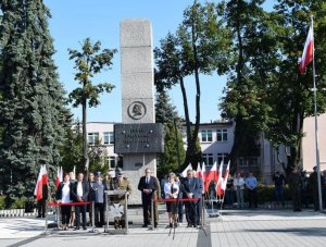 Przed pomnikiem Piłsudskiego w Sieradzu  stoją przedstawiciele służb mundurowych przemawia Prezydent Miasta Sieradza