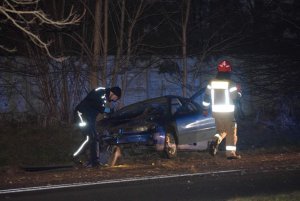 wrak rozbitego auta obok policjant i strażak