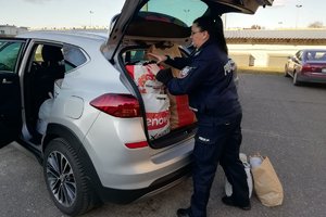 policjantka  pakuje do samochodu torby z przekazanymi rzeczami od policjantów dla ukraińskich rodzin