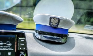czapka policjanta ruchu drogowego leży na podszybiu radiowozu