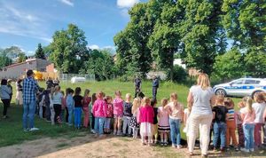 umundurowani policjanci uczestniczą w spotkaniu z dziećmi, pokaz psa służbowego