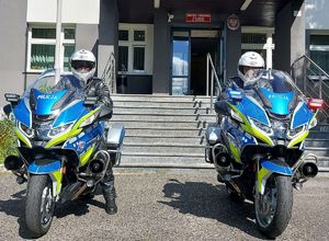 przed budynkiem komendy umundurowani policjanci siedzą na oznakowanych nowych motocyklach