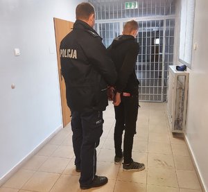 w areszcie umundurowany policjant zakłada zatrzymanemu kajdanki