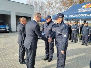 Uroczystość otwarcia nowej siedziby Komisariatu Policji w Warcie – Komendant Powiatowy Policji w Sieradzu oraz Komendant Komisariatu Policji w Warcie, wręczają pamiątkowe ryngrafy Burmistrzowi Warty i Wójtowi Gminy Goszczanów , po prawej stronie namiot gdzie stoją zaproszeni goście