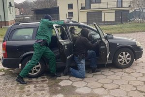 ćwiczenia w zakładzie karnym z udziałem policji służby więziennej i staży pożarnej, funkcjonariusze z bronią w ręku stoją przy samochodzie