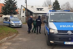 ćwiczenia w zakładzie karnym z udziałem policji służby więziennej i staży pożarnej, funkcjonariusze policji prowadza zatrzymanego,