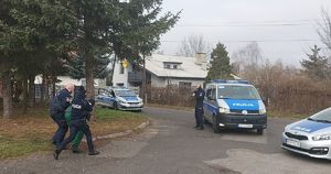 ćwiczenia w zakładzie karnym z udziałem policji służby więziennej i staży pożarnej, policjanci prowadzą zatrzymanego widać radiowozy