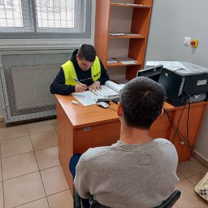 w pokoju służbowym policjant przesłuchuje mężczyznę,