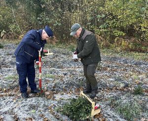 Umundurowani policjanci bierą udział w akcji sadzenia lasu.