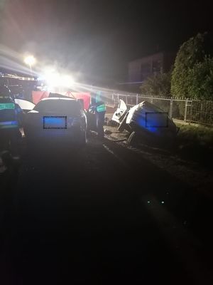 Miejsce wypadku drogowego, na miejscu pracują służby ratunkowe, policja, straż pożarna, widać uszkodzone pojazdy biorące udział w zdarzeniu.