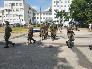 Piknik przed budynkiem komendy, rozstawione są namioty wystawców, pojazdy służb mundurowych, osoby odwiedzają stoiska.