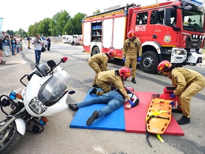 Piknik przed budynkiem komendy, rozstawione są namioty wystawców, pojazdy służb mundurowych, osoby odwiedzają stoiska.