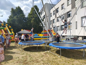 Piknik przed budynkiem komendy, rozstawione są namioty wystawców, pojazdy służb mundurowych, osoby odwiedzają stoiska.