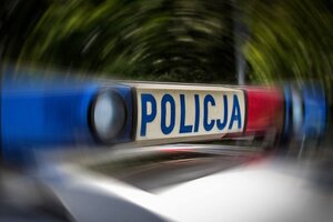 Dach policyjnego radiowozu z włączonymi sygnałami błyskowymi.
