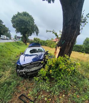 Na zdjęciu widać stojący uszkodzony  w rowie przy drzewie  pojazd koloru niebieskiego